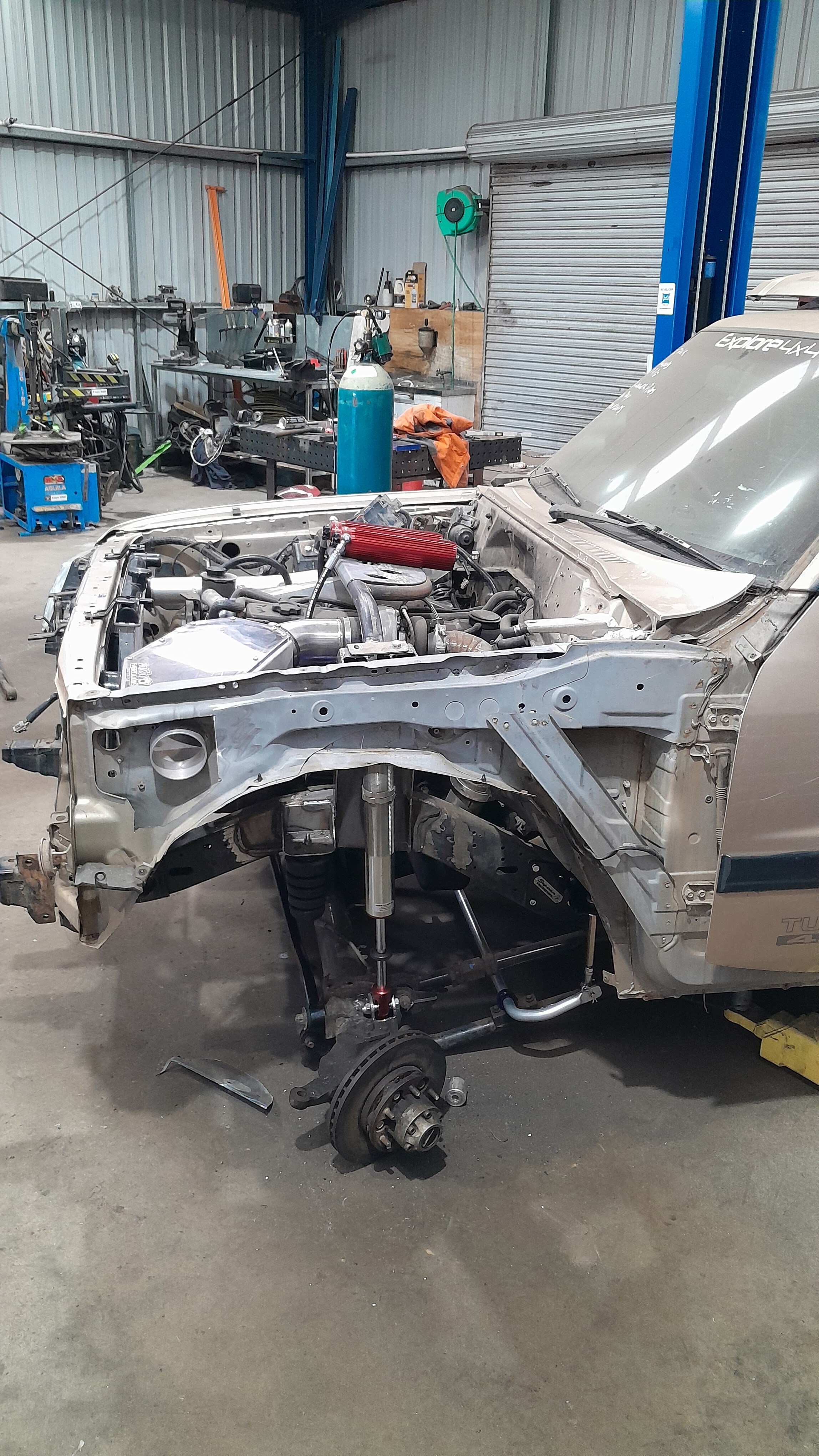A four wheel drive stripped back to the bare front end inside the workshop during a rebuild